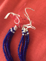 Close up illustrating the use of recycled raw materials in the contruction of the blue and white beaded necklace