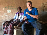 Image of artisan in East Africa selling to Trutogs owner his blue and white handcrafted beaded necklace